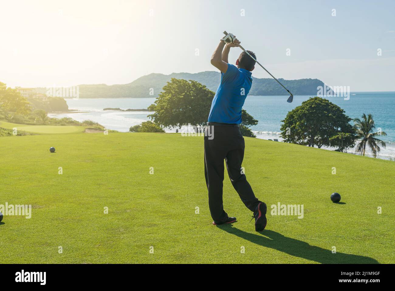 Latin golf instructor teaching the swing in the morning Stock Photo