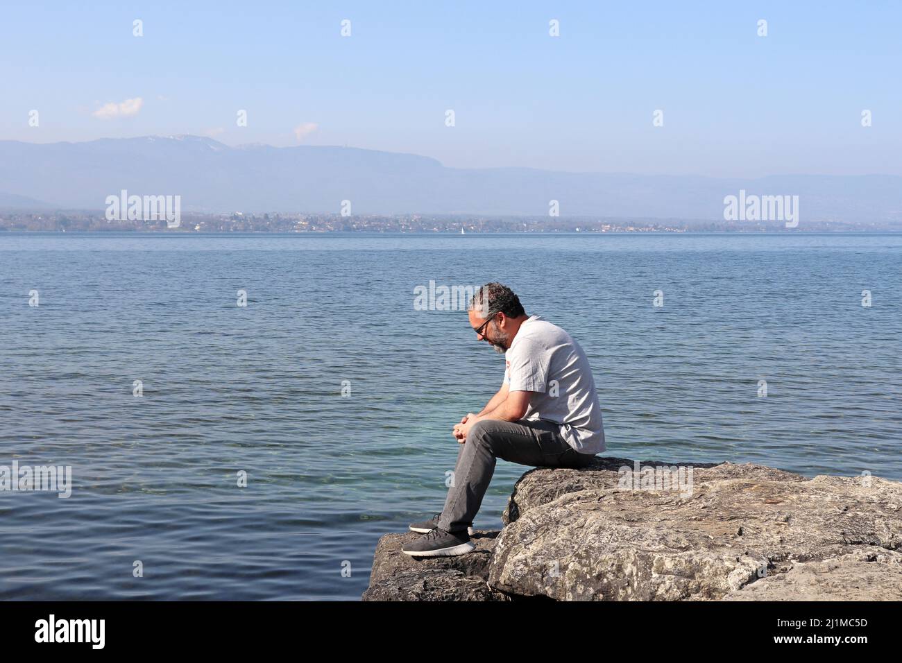 Male sitting on a rock looking back hi-res stock photography and images ...