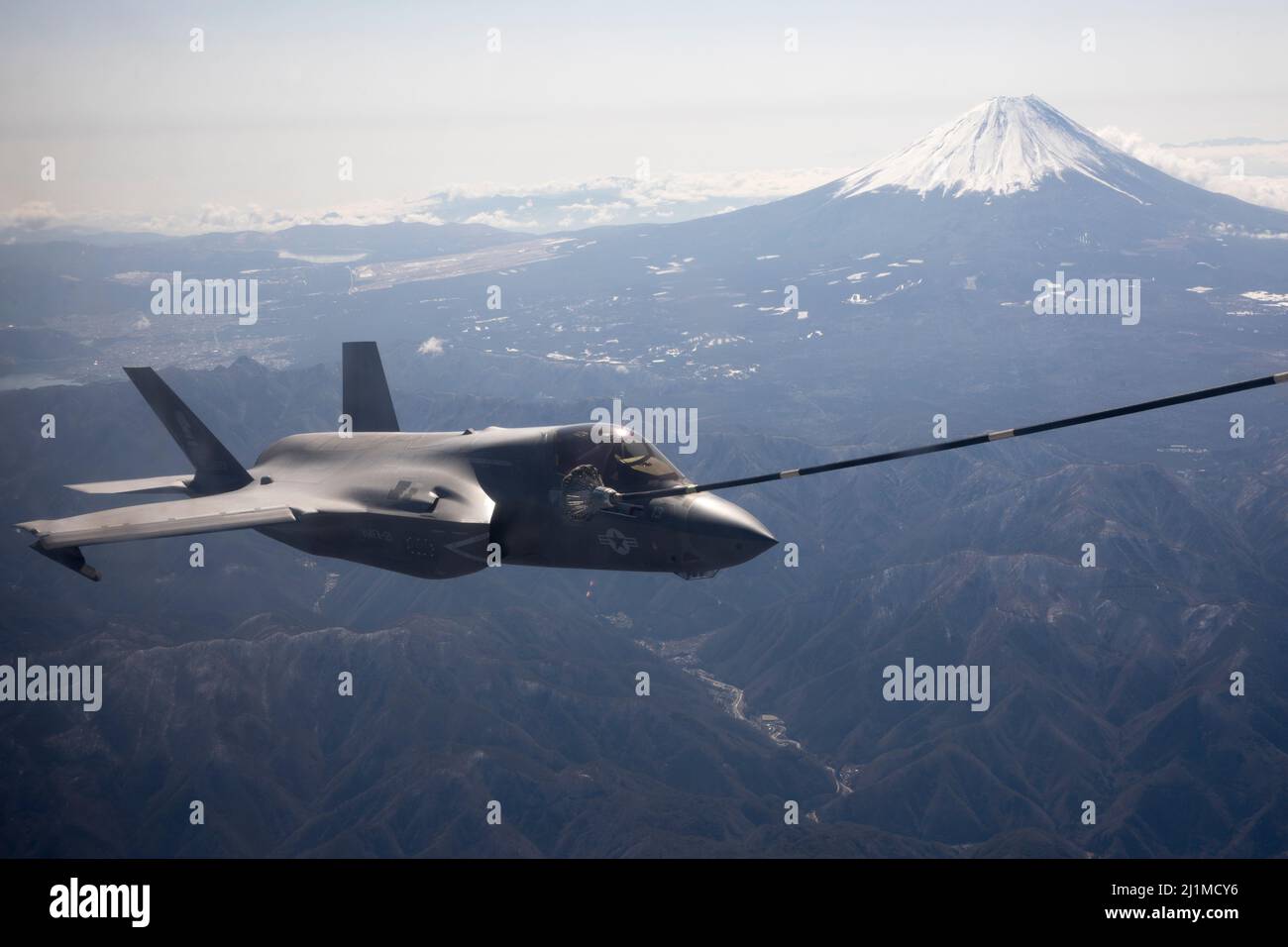 A U.S. Marine Corps F-35B Lightning II with Marine Fighter Attack Squadron (VMFA) 121 conducts aerial refueling with Marine Aerial Refueler Transport Squadron (VMGR) 152 near Mt. Fuji, Japan, March 24, 2022. Marines with VMGR-152 supported Marines with VMFA-121 during a training flight simulating close air support at Camp Fuji, Japan. Marine Corps aviation routinely conducts training throughout the region to remain combat-ready in support of a free and open Indo-Pacific and to demonstrate our commitment to the Treaty of Mutual Cooperation and Security between the U.S. and Japan. (U.S. Marine C Stock Photo