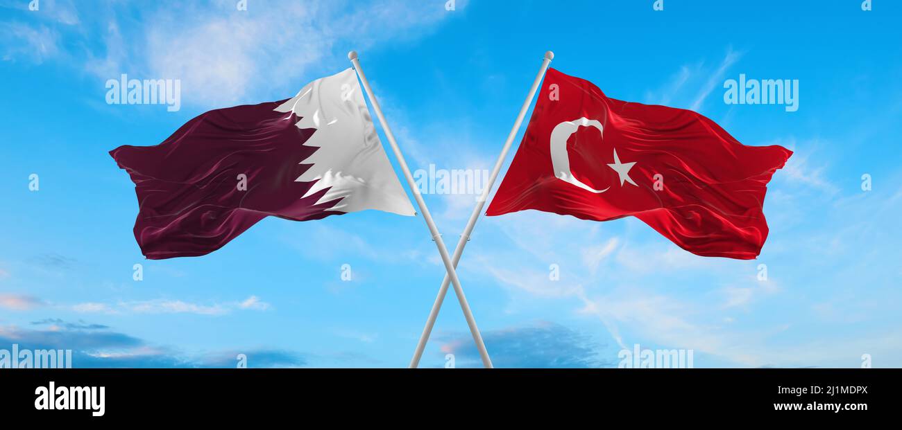 two crossed flags Qatar and Turkey waving in wind at cloudy sky ...