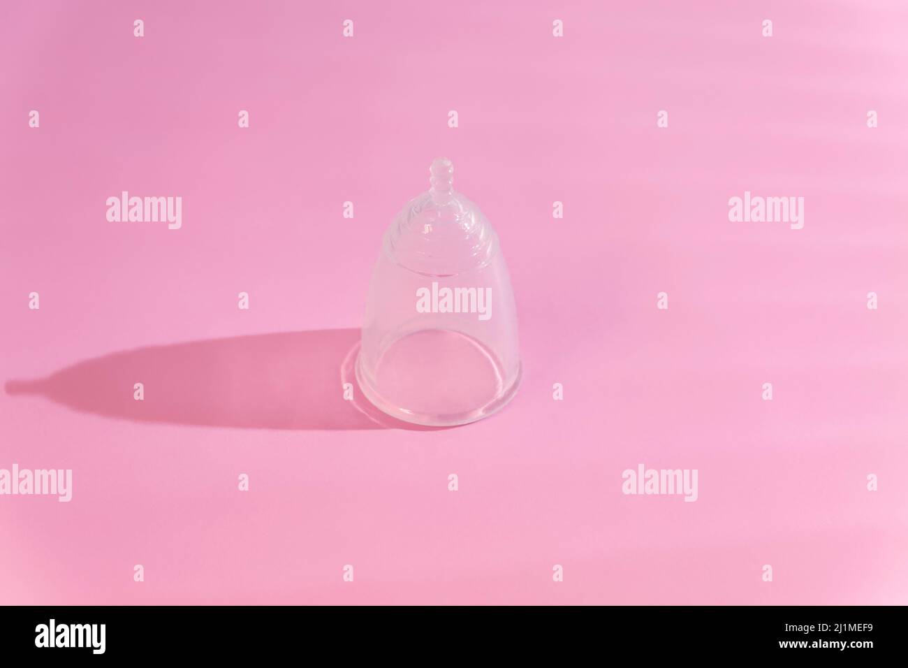 Eco menstrual cup on pink background with creative shadows Stock Photo