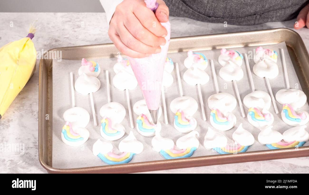 Step by step. Piping meringue mix into unicornshaped pops on a baking