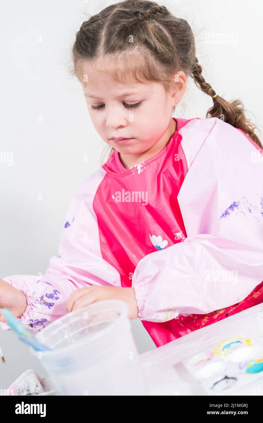 Homeschooling during COVID19 lockdown. Little girl painting paper