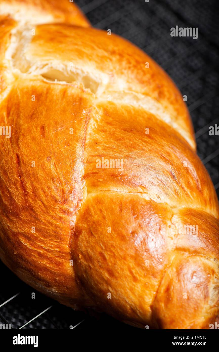 Beautiful three braid golden baked bread with egg wash. Challah is a