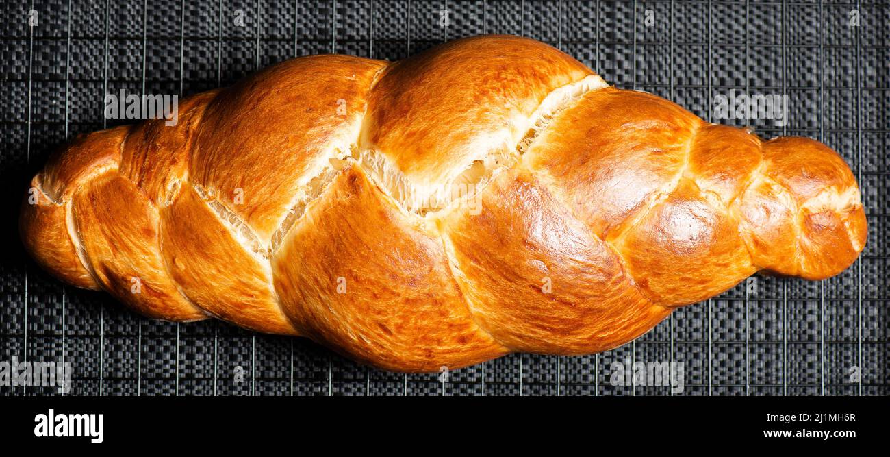 Beautiful three braid golden baked bread with egg wash. Challah is a