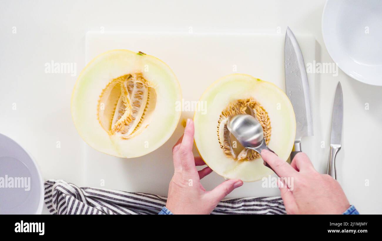 Step by step. Flat lay. Slicong golden dewlicious melon on a white cutting board Stock Photo Alamy