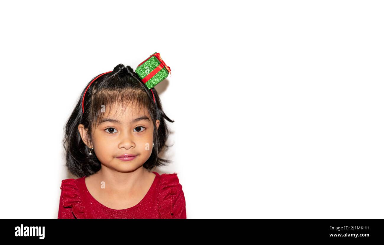 Portrait of a very cute little girl with a gift bow on her head.She is ...