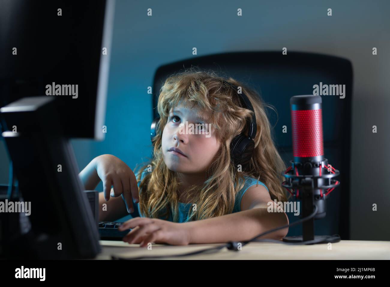 A little boy child uses a desktop at night, a child with computer ...