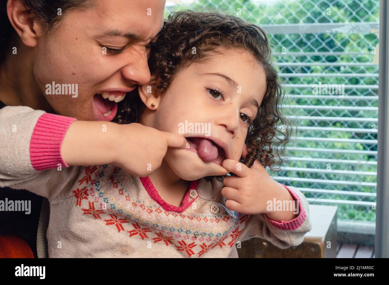 father and daughter smiling and having fun together in family indoors