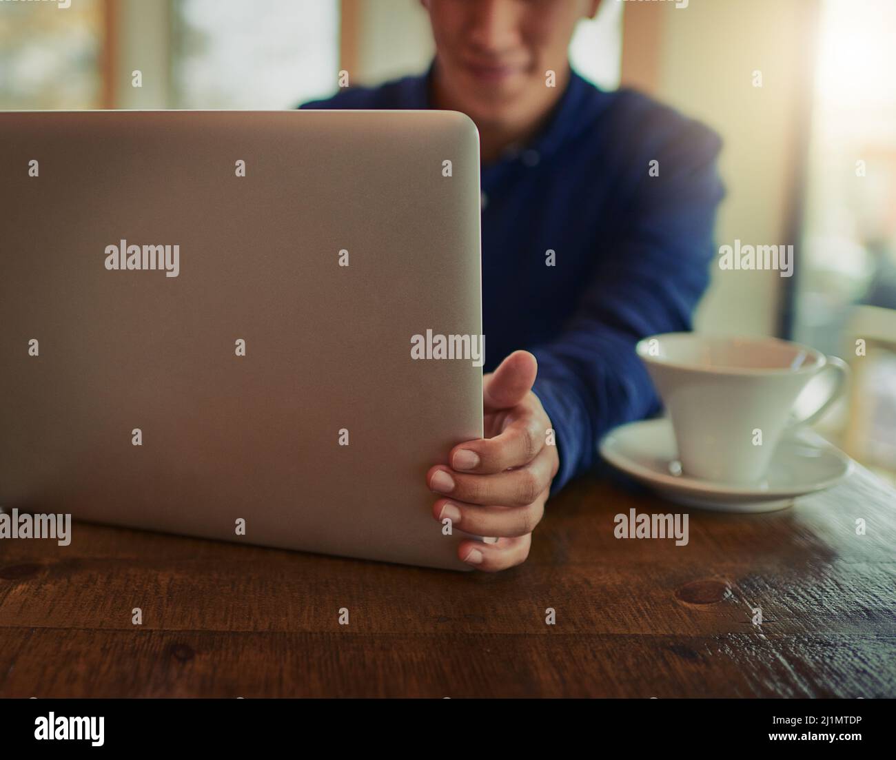 Open up to the world wide web. Cropped shot of a man using a laptop in a cafe. Stock Photo