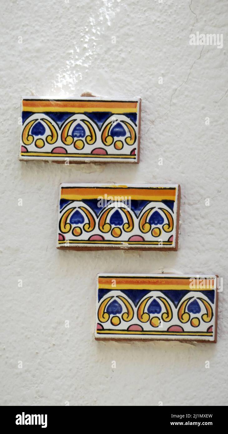 Decorative tile cuttings on whitewashed wall in Andalusian village house Stock Photo