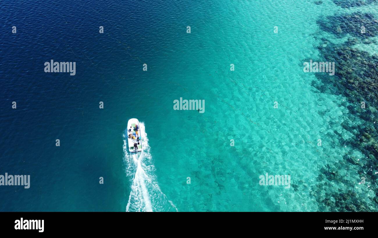An aerial view of a boat sailing in turquoise water Stock Photo - Alamy