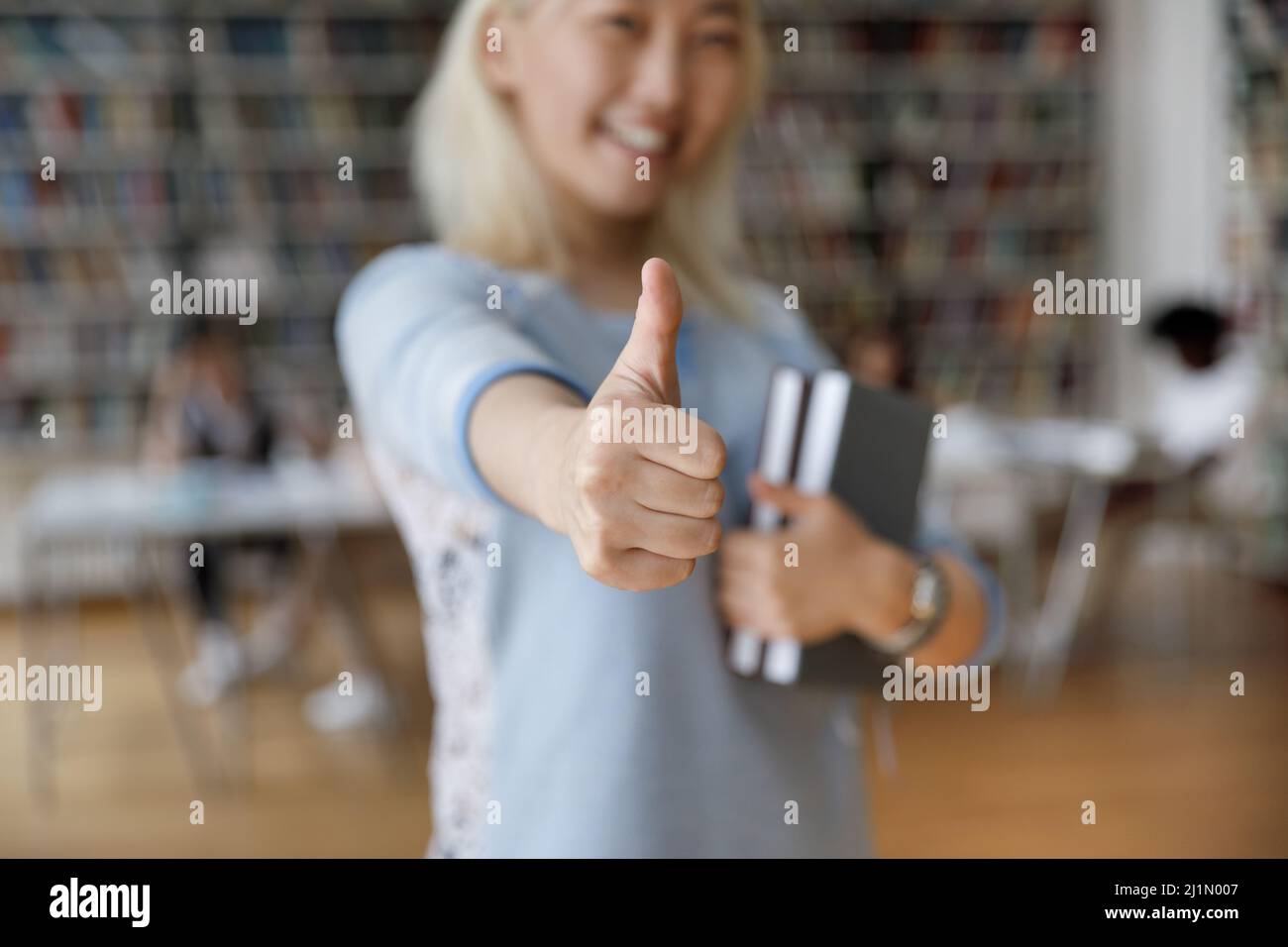Asian student girl standing in library showing thumb up, closeup Stock ...