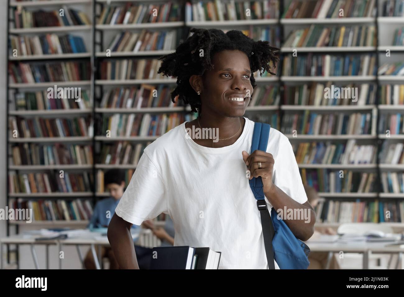 Happy African student guy posing in campus library Stock Photo