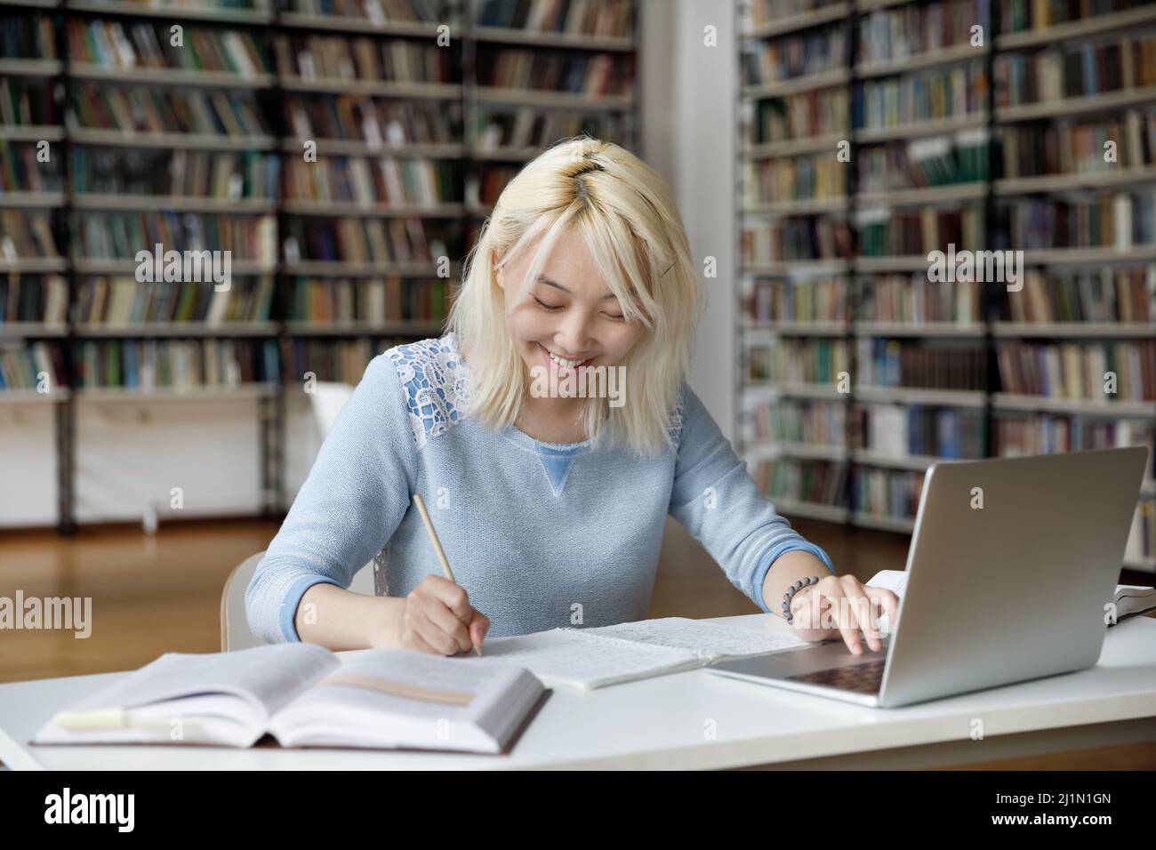 Asian girl studying sit at table in library Stock Photo - Alamy