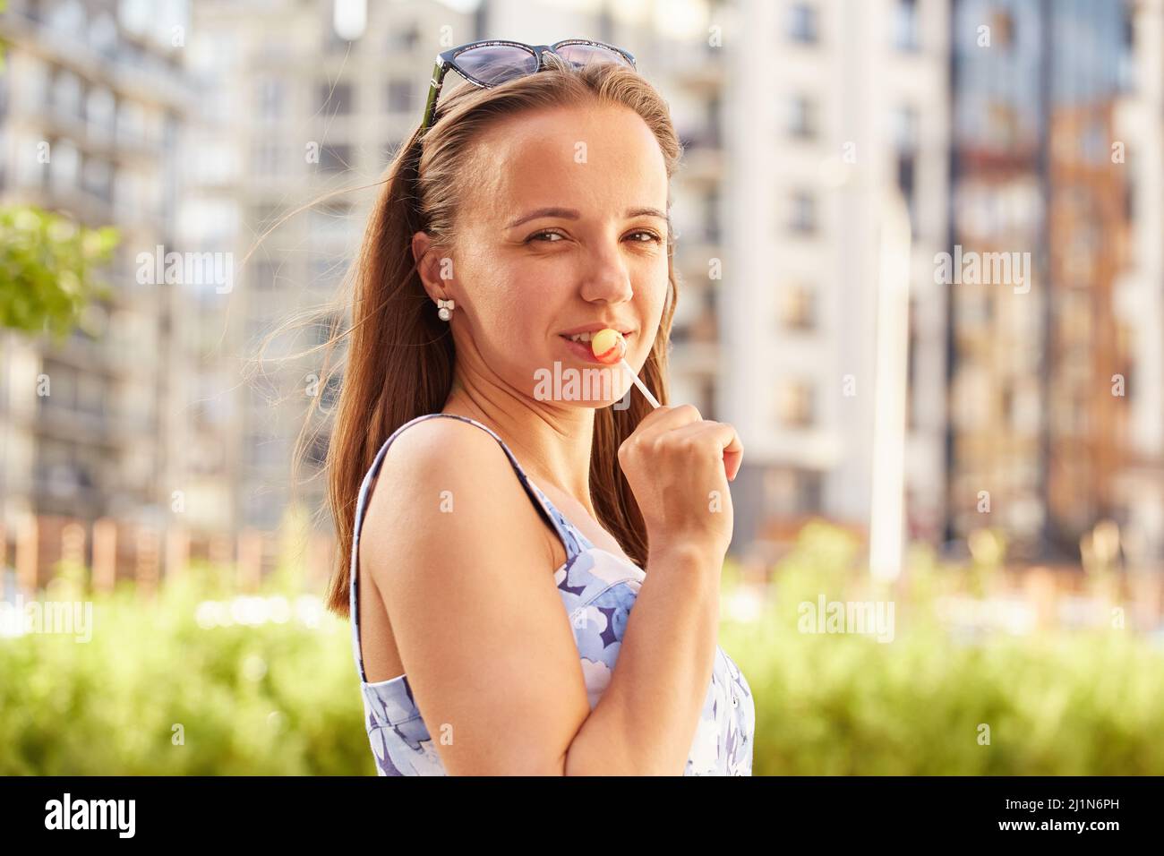 happy young woman with lollipop looking at camera Stock Photo