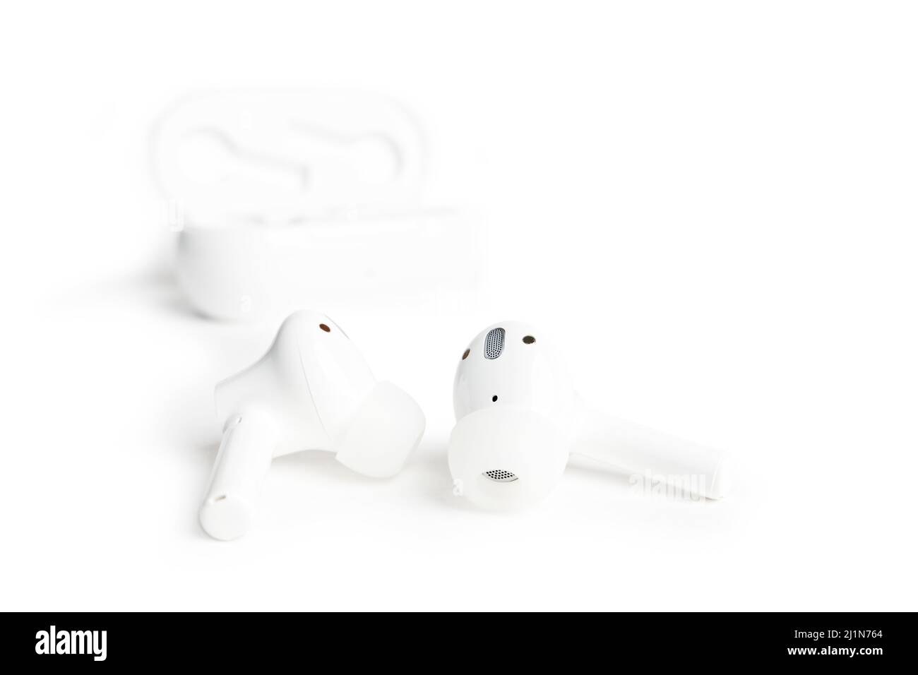Closeup abstract white TWS (true wireless stereo) earbuds isolated on white background. Shallow focus. Stock Photo