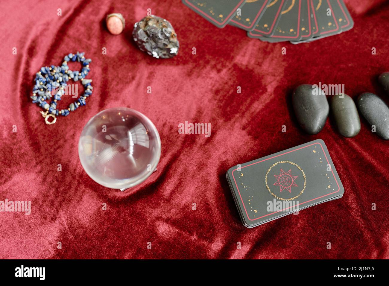 Top view background image of tarot cards and crystals on red velvet table in fortune tellers shop, copy space Stock Photo