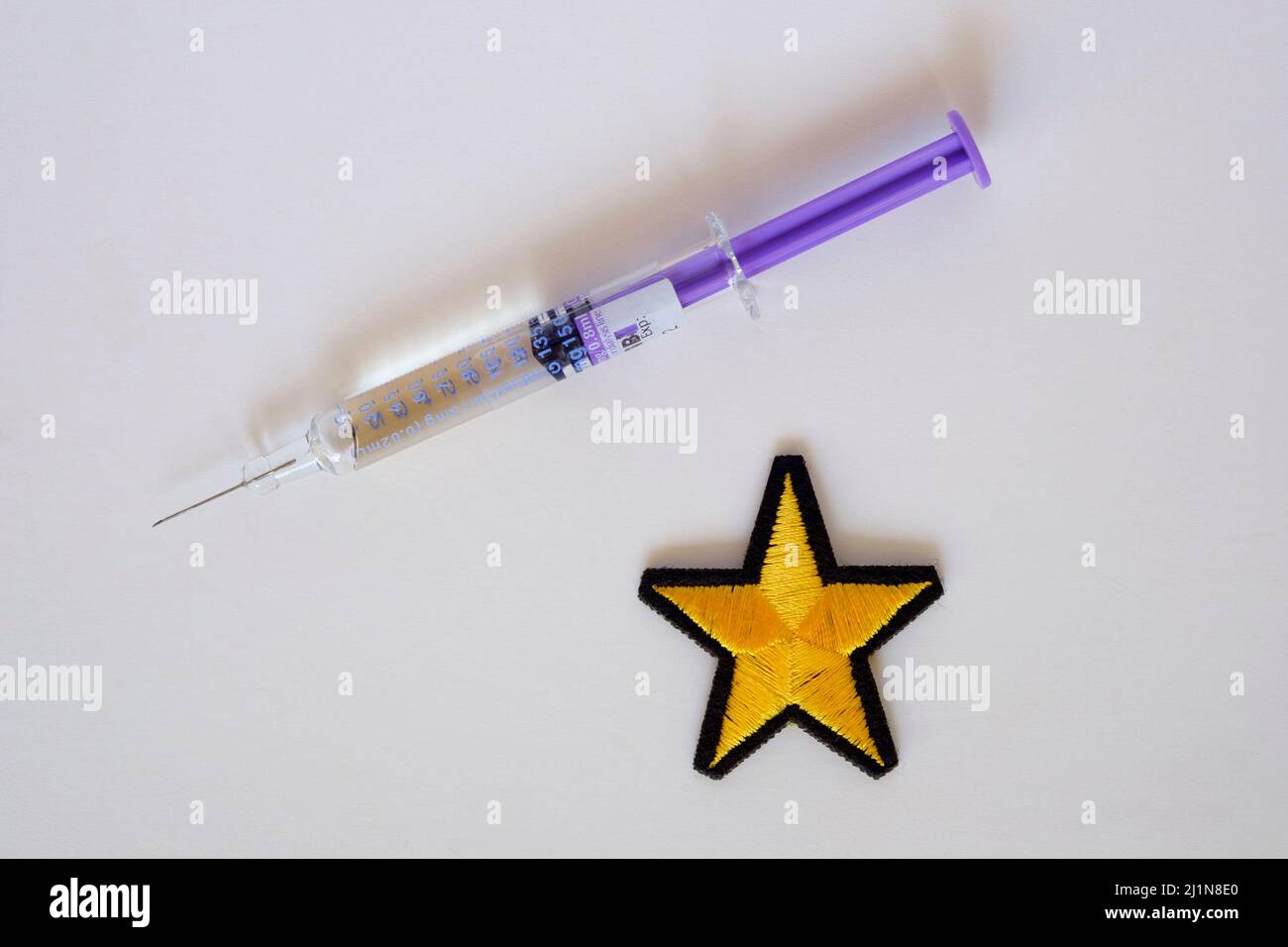 concept image syringe yellow star illustrating discrimination medical apartheid differentiating between vaccinated non covid vaccination takers Stock Photo