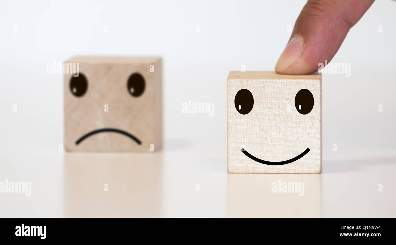 Businessman chooses a smile emoticon icons face happy symbol on wooden block , Services and Customer satisfaction survey concept Stock Photo