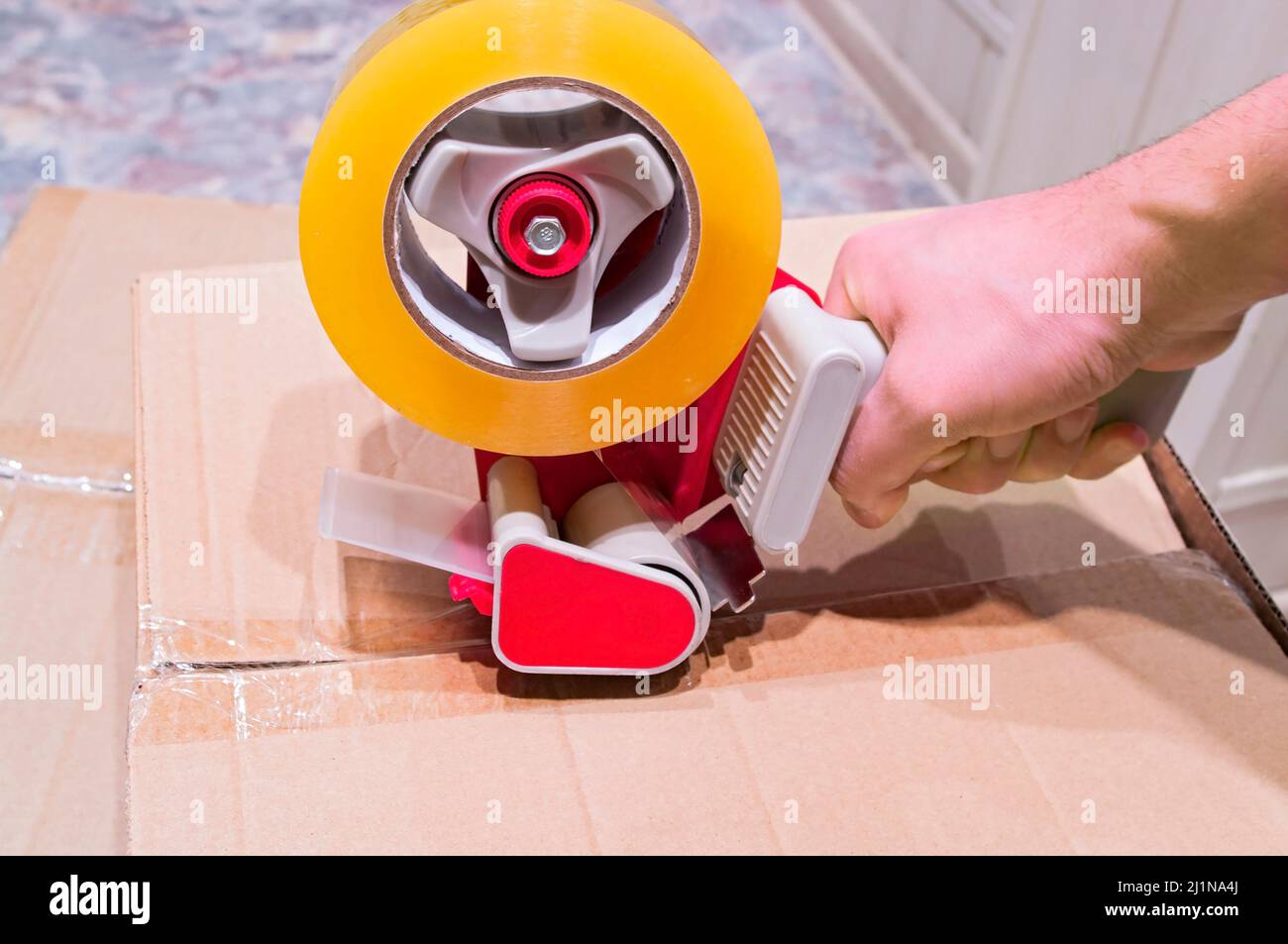 Packaging parcels with scotch tape dispenser closeup Stock Photo Alamy