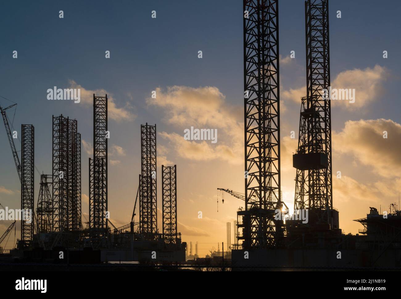 Silhouettes of disused oil rigs ready for recycling at sunset in the port of Vlissingen, Zeeland, Netherlands Stock Photo