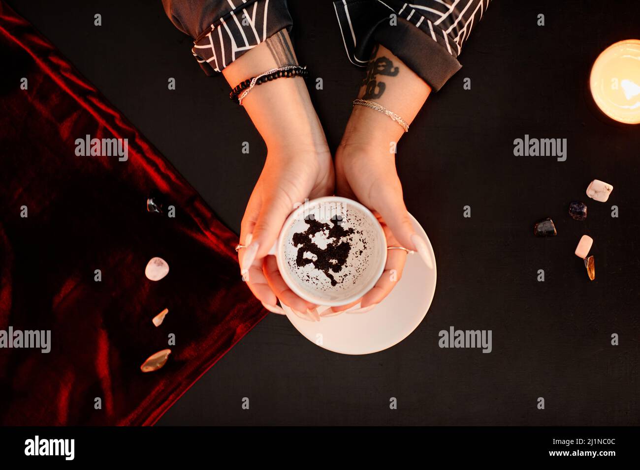 Top down view of female fortune teller holding coffee cup in hands and