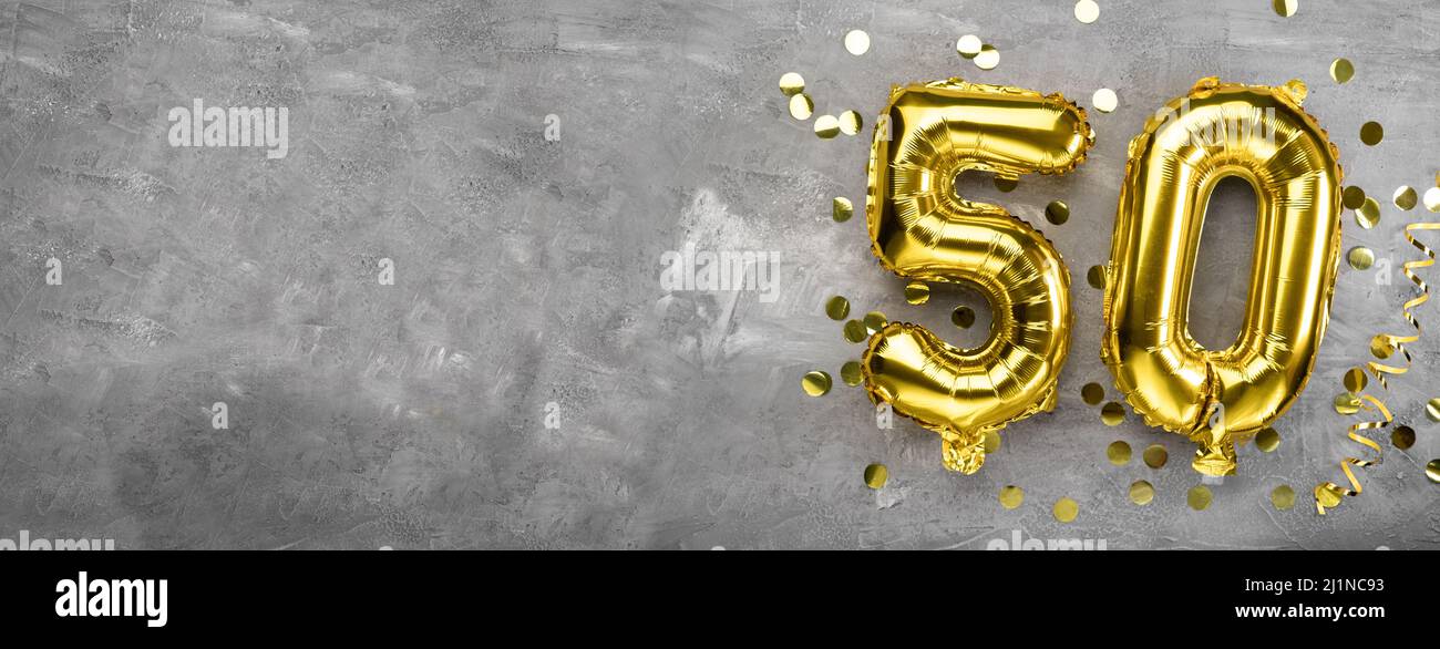 Yellow foil balloon number, number fifty background concrete. Greeting