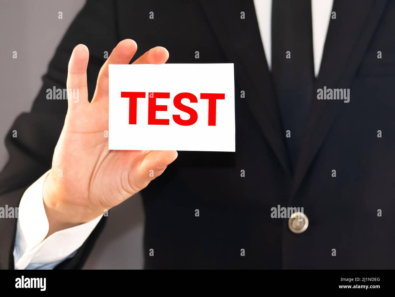 Hand in blue glove, pen, white note with word 'test'. Medical concept