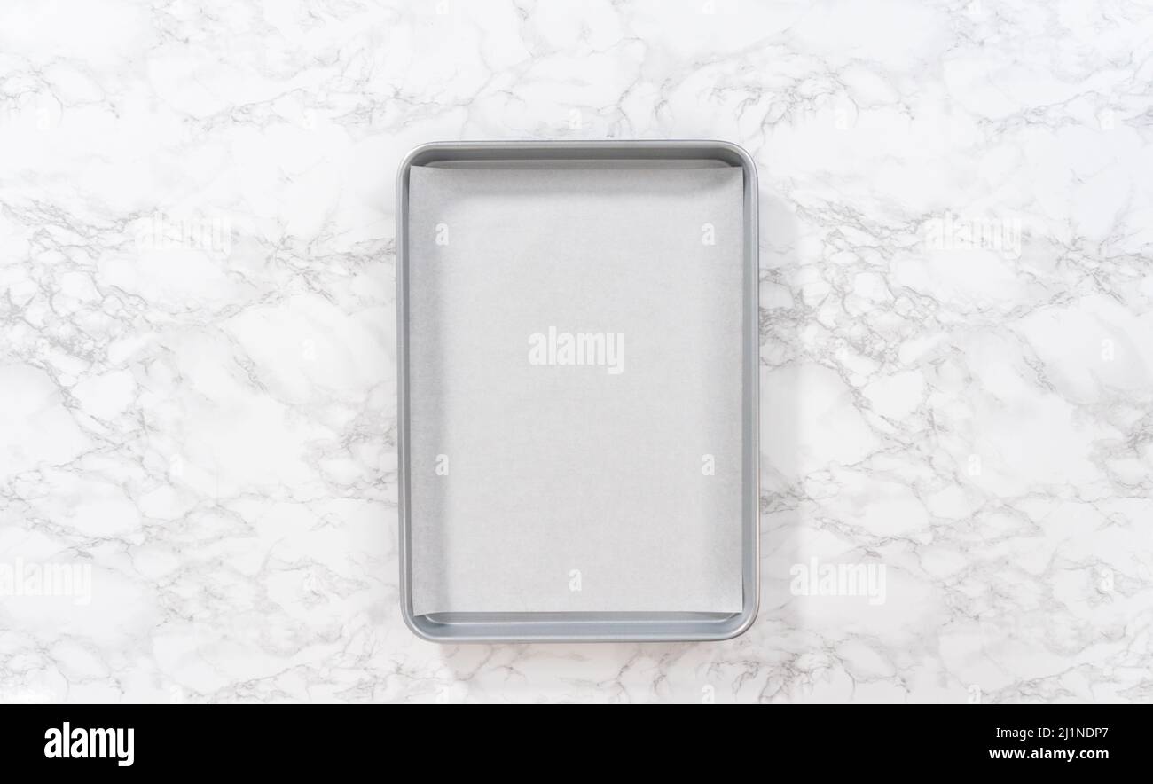 Spreading organic pecans on a baking sheet lined with parchment paper