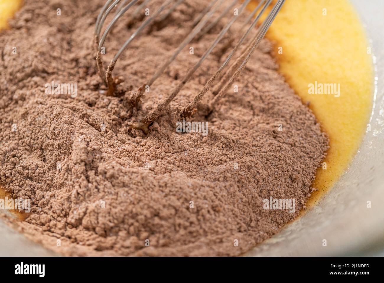 Mixing ingredients in a glass mixing bowl with a blending whisk to bake