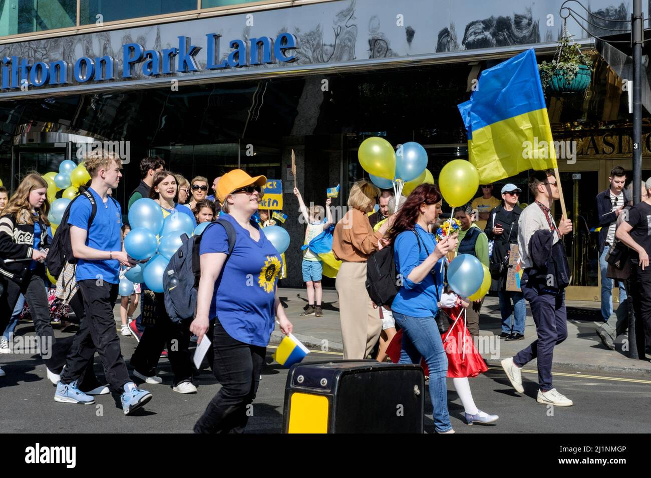 London UK, 26th March 2022. Thousands of people join a Stand with Ukraine march  and vigil in central London in protest against the Russian invasion. A group of young protesters pass the London Hilton on Park Lane hotel at the start of the march. Stock Photo