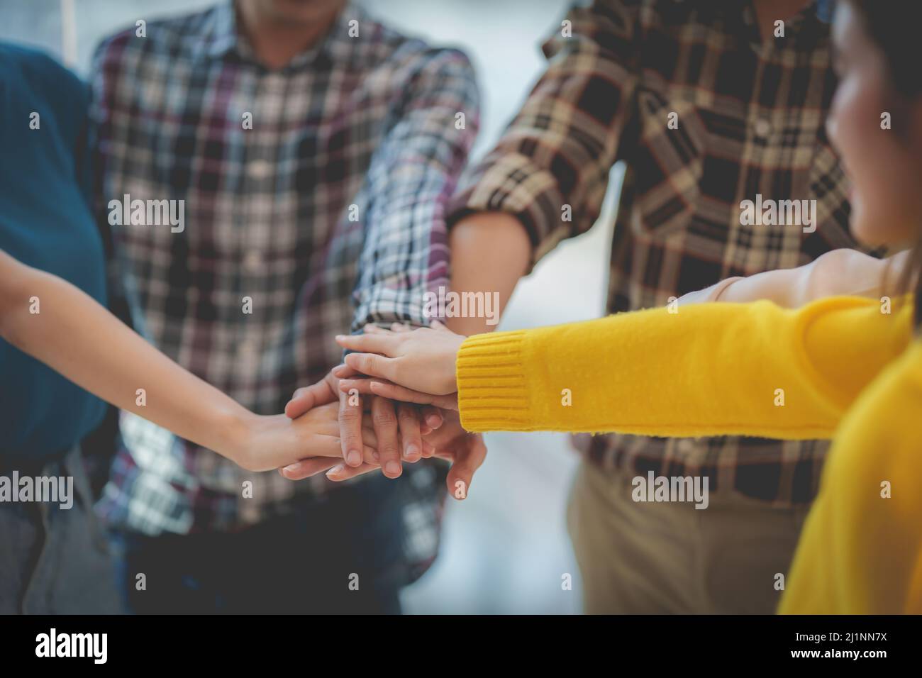 Group of Multiracial people putting their hands working together showing oneness symbol. Stock Photo