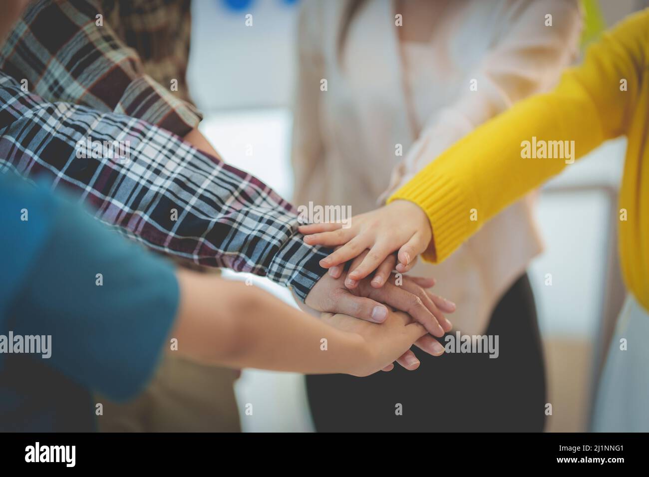 Group of Multiracial people putting their hands working together showing oneness symbol. Stock Photo