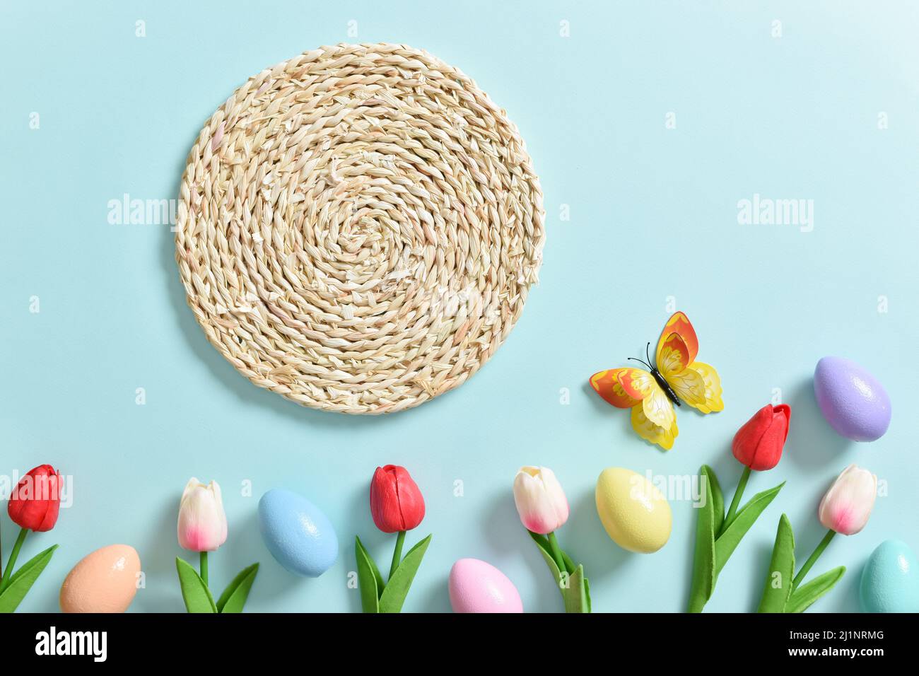 Spring composition with tulip flowers, Easter colored eggs and butterflies. Stock Photo