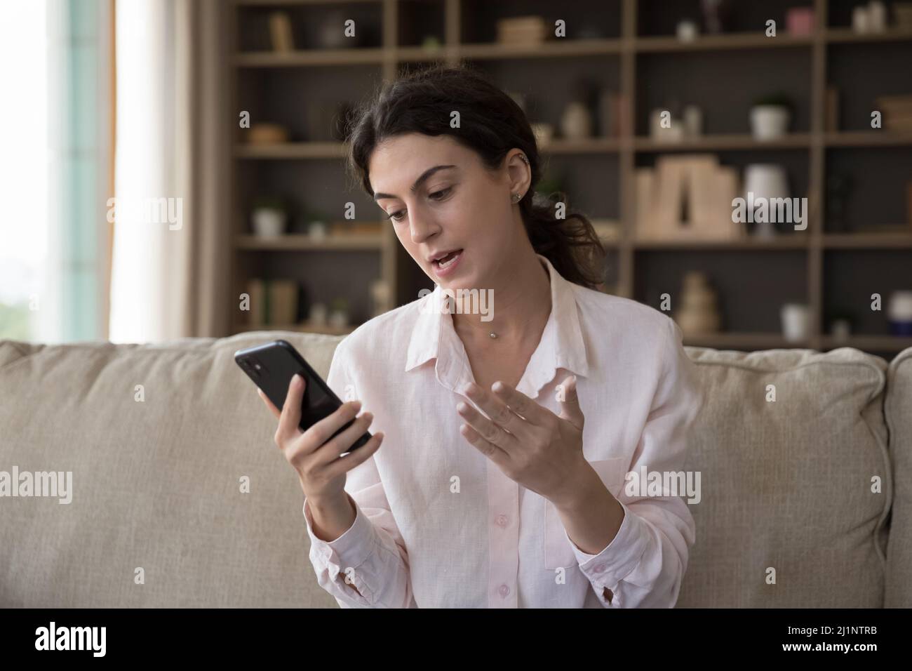 Focused pretty girl talking on mobile phone, making video call Stock ...