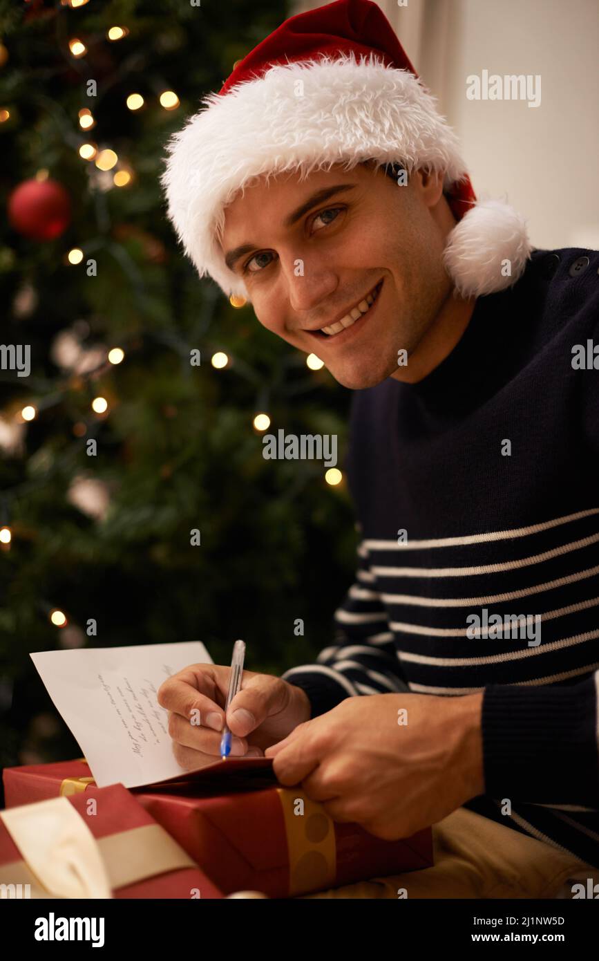 Playing Santa. Shot of a handsome young man getting ready for ChristmasShot of a handsome young man getting ready for Christmas. Stock Photo