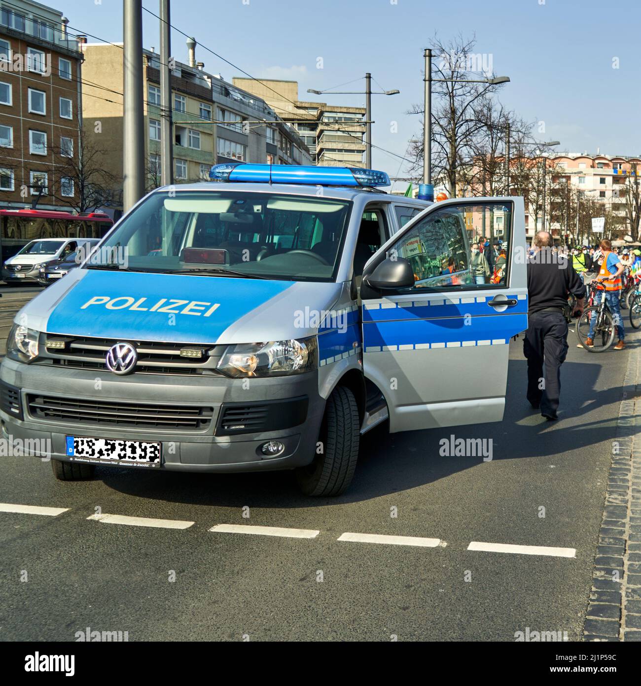 Braunschweig, Germany, March 25, 2022: German police car, VW bus and van, with open driver's door and blue light on Stock Photo