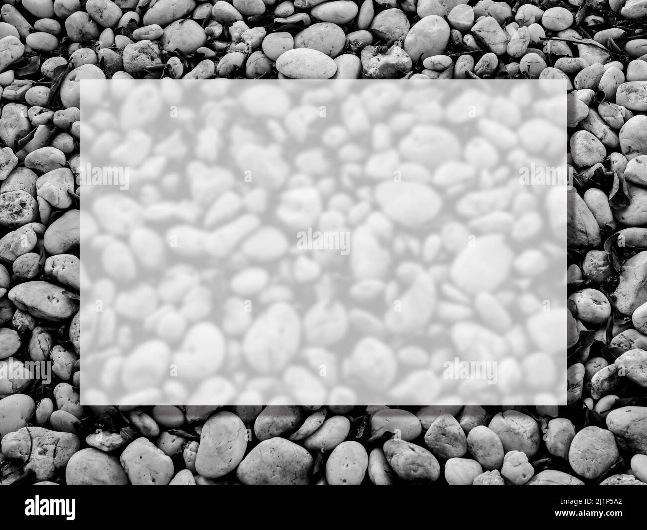 A transparent glass square border frame on the many white beach gravel stones texture surface background, top view. Empty blank space for summer, vaca Stock Photo