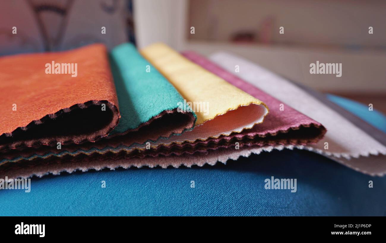 Closeup colorful upholstery fabric samples on blue background. Example
