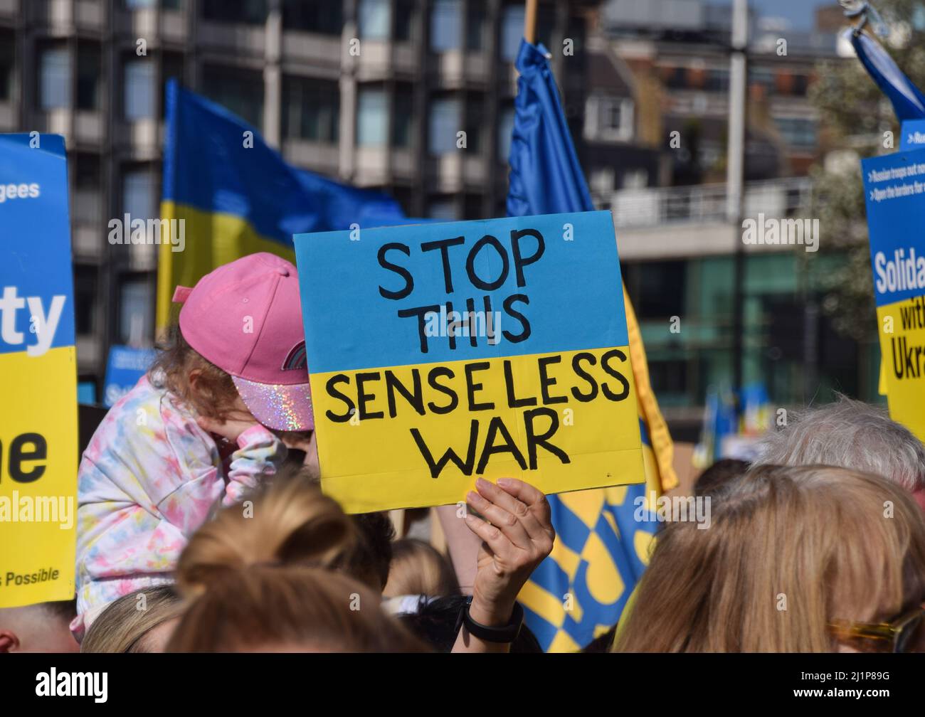 A protester in Park Lane holds a placard which reads 'Stop this senseless war', during the 'London Stands With Ukraine' march. Thousands of people marched from Park Lane to Trafalgar Square in solidarity with Ukraine as Russia continues its attack. Stock Photo