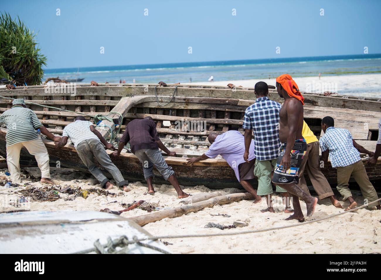 Zanzibar City, Tanzania-January 02,2019: Local fishermen are repairing their boats on the beach of Zanzibar Island. Stock Photo