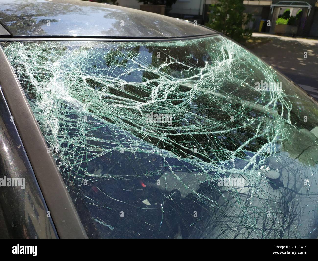 Broken glass of the broken windshield after a heavy car accident ruined the windscreen and caused an injury that shattered and cracked the glass Stock Photo
