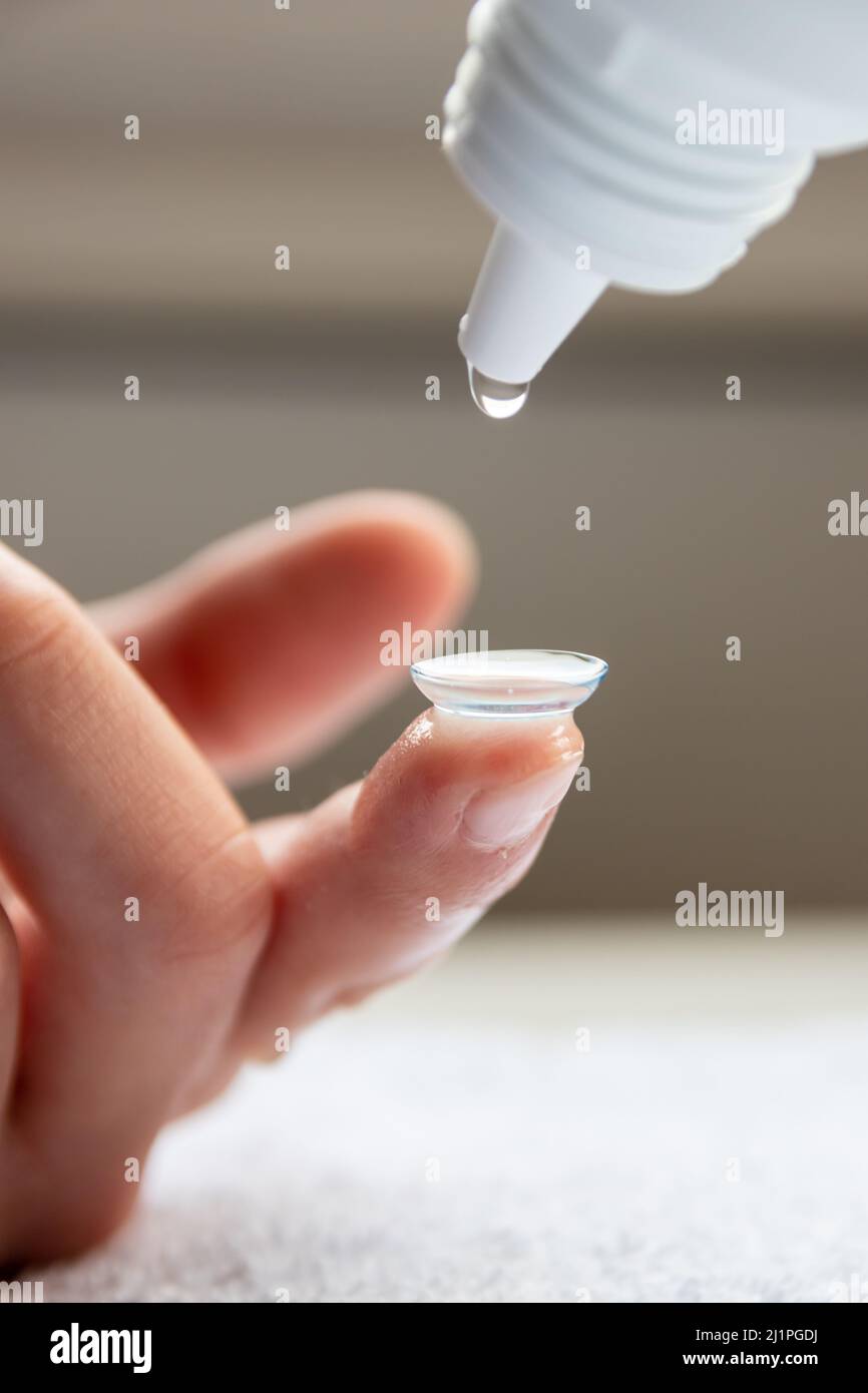 Contact lense cleaning on finger to correct nearsightedness and blurred vision eyesight by optician or oculist is to handle with hygiene to correct Stock Photo