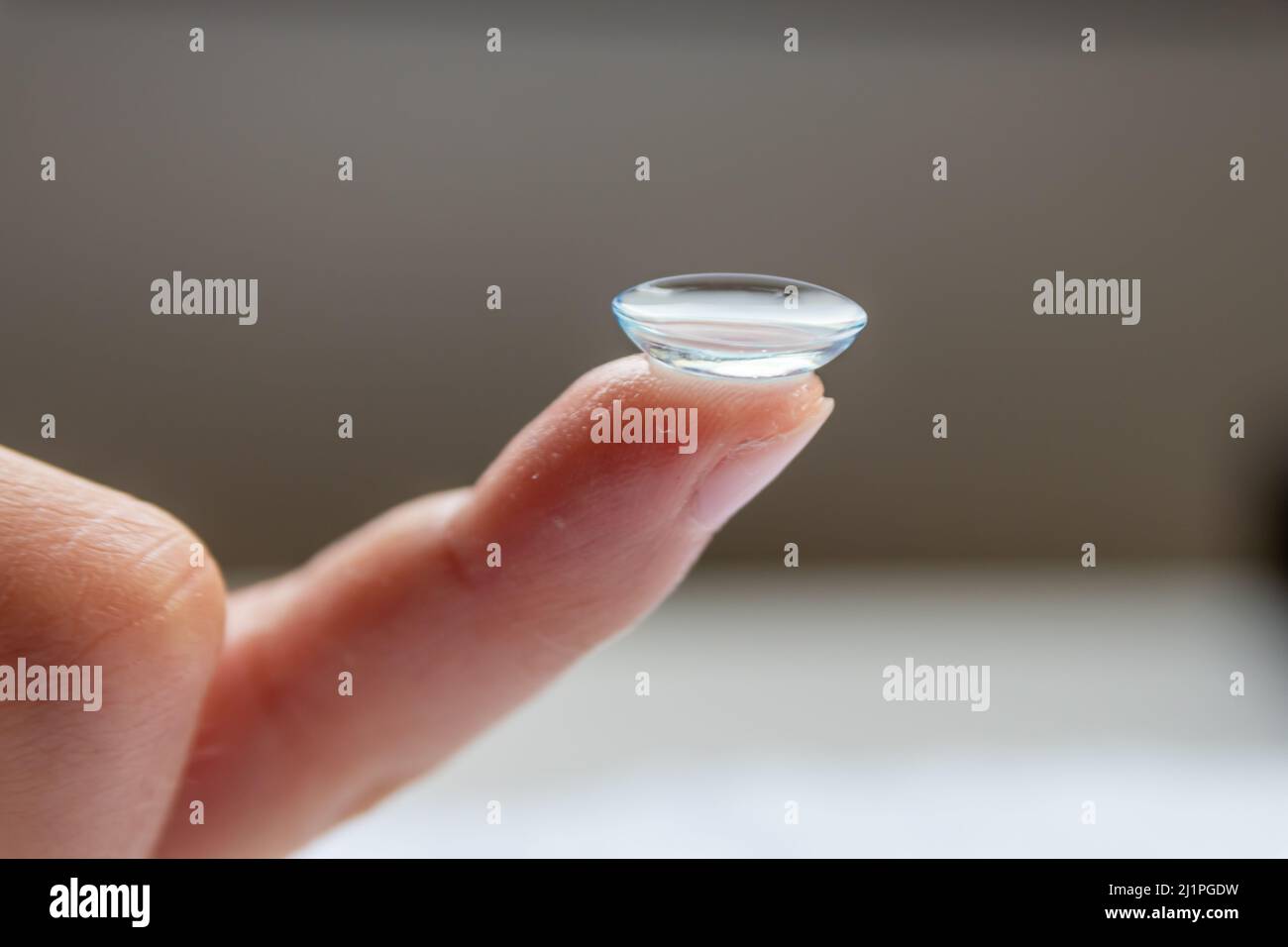 Contact lense cleaning on finger to correct nearsightedness and blurred vision eyesight by optician or oculist is to handle with hygiene to correct Stock Photo