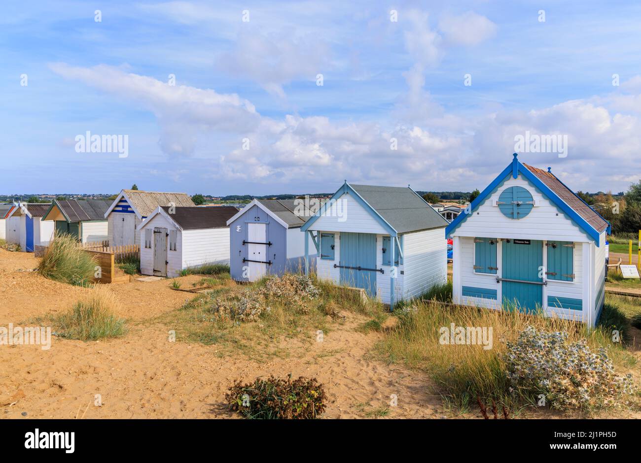 Wooden beach huts on the seafront behind sand dunes at Heacham North