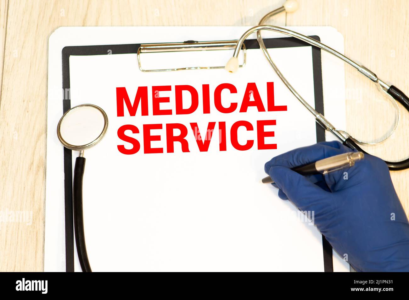 Text Medical Service write on a medical notebook. Background on the yellow table with a stethoscope and pen. medicine and health concept Stock Photo