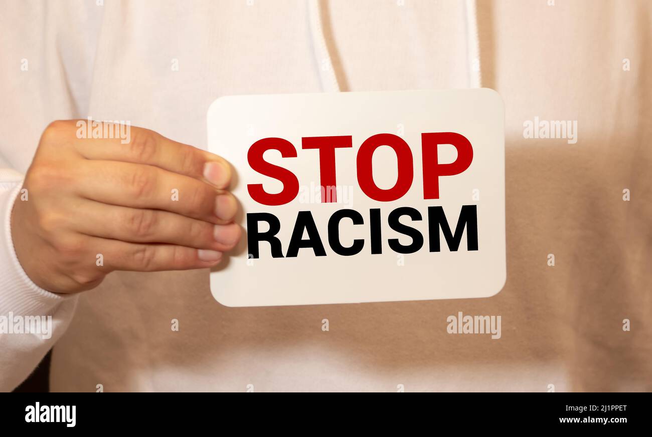 End Rasim Small Text on a small chalkboard STOP RACISM in the hands of a girl. Isolated ...