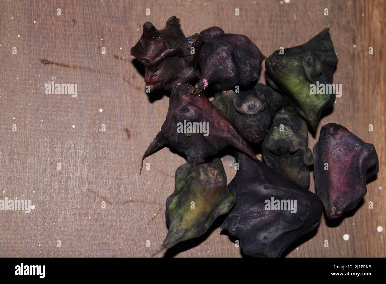 water caltrop fruit on the wooden background. Stock Photo