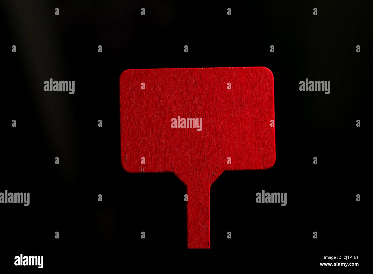 Red wooden plate on a dark background. Mock-up. Stock Photo